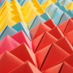 Kolorowe papierowe piramidy ułożone w geometryczny wzór