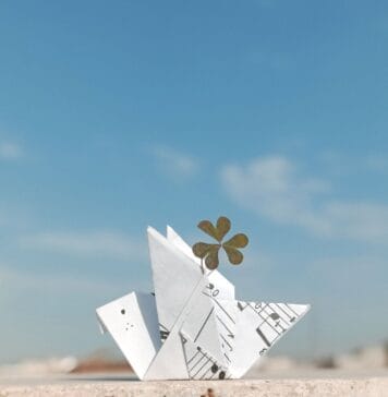 Dlaczego kwiat lotosu origami się rozpada? 6 przyczyn i proste rozwiązania Papierowy żuraw origami z koniczyną na tle błękitnego nieba